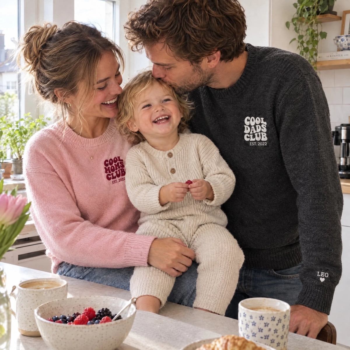 Eltern mit Kleinkind in der Küche in Cool Dads und Cool Moms Club Pullovern