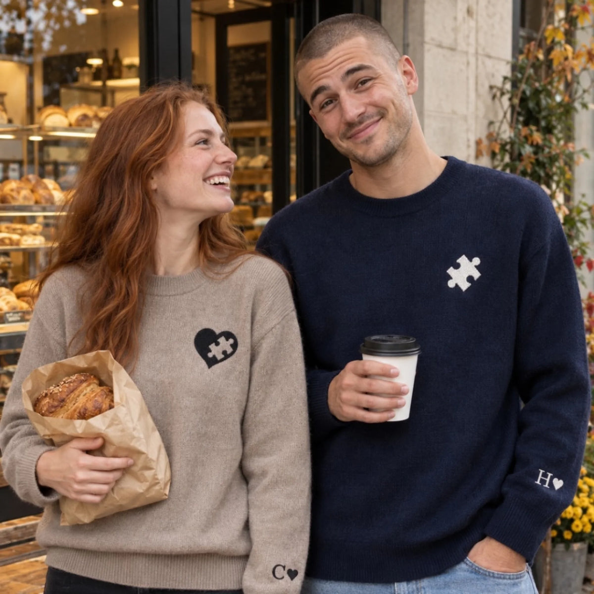 Paar vor einer Bäckerei in Partner-Pullovern